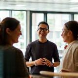 Several team members gathered smiling and talking in a bright, comfortable office space